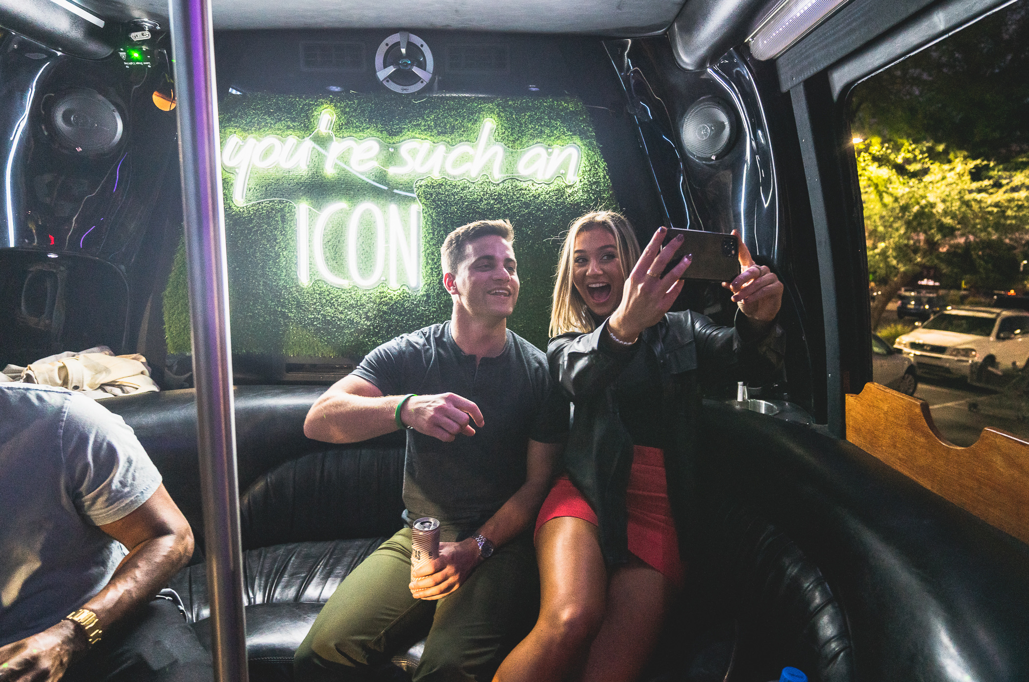 Party-goers taking a selfie in front of LED sign